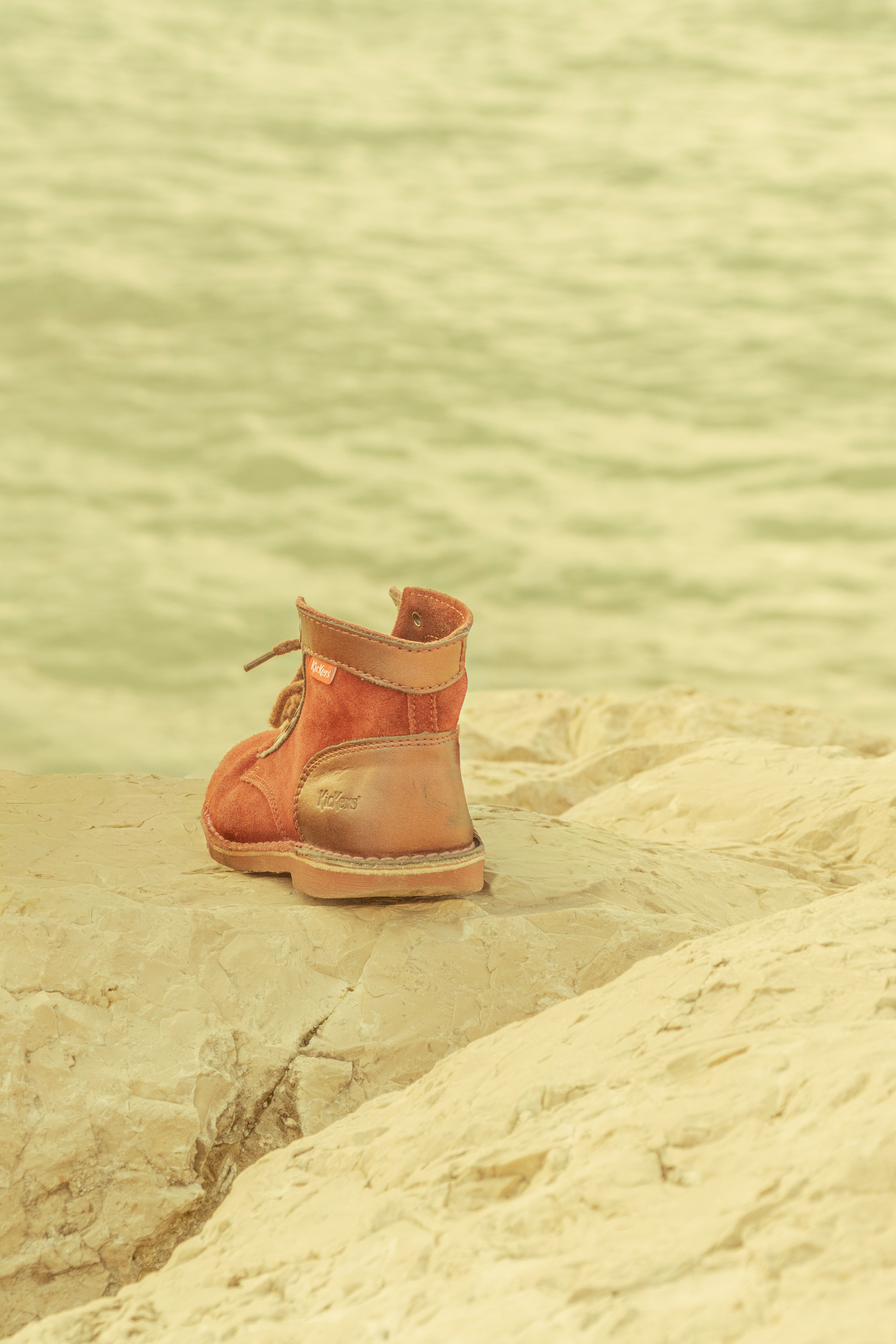 Chaussure Kickers posée sur un rocher au bord de l'eau