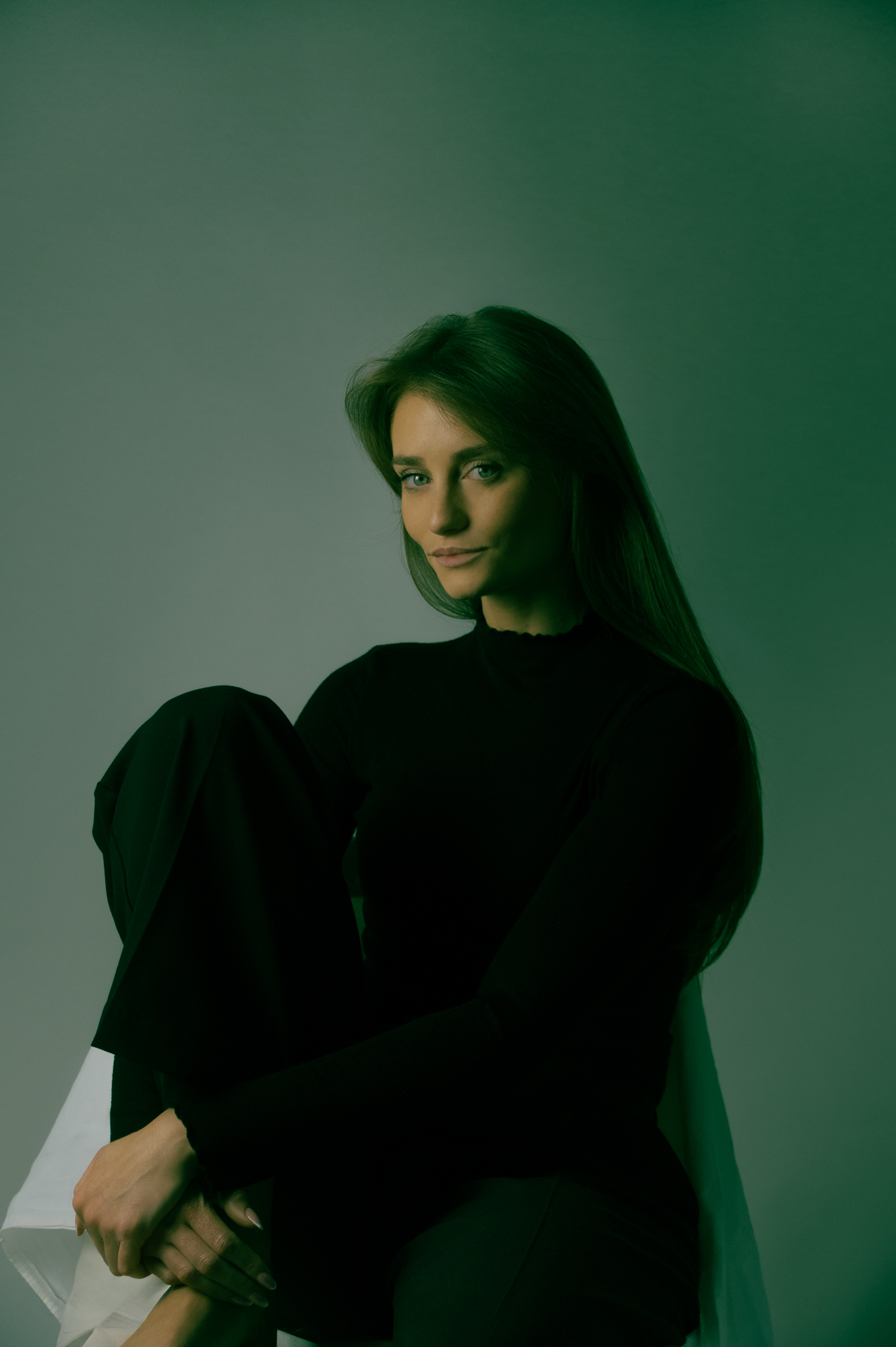 Amélie — portrait assis, haut noir, fond vert