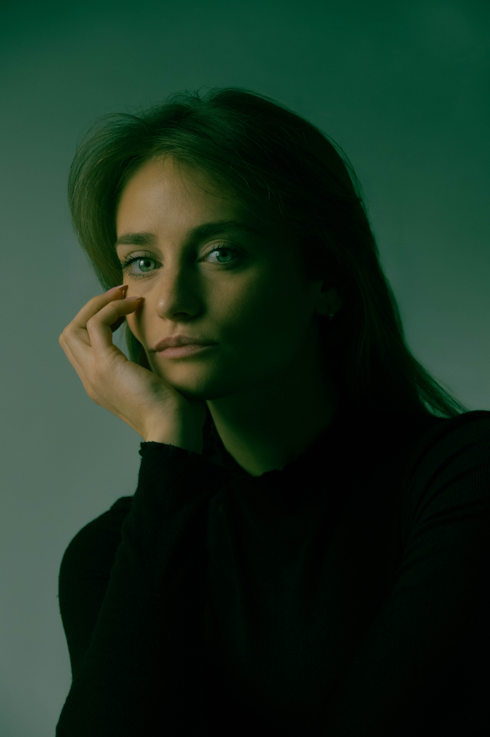 Amélie — portrait studio, main au visage, fond vert