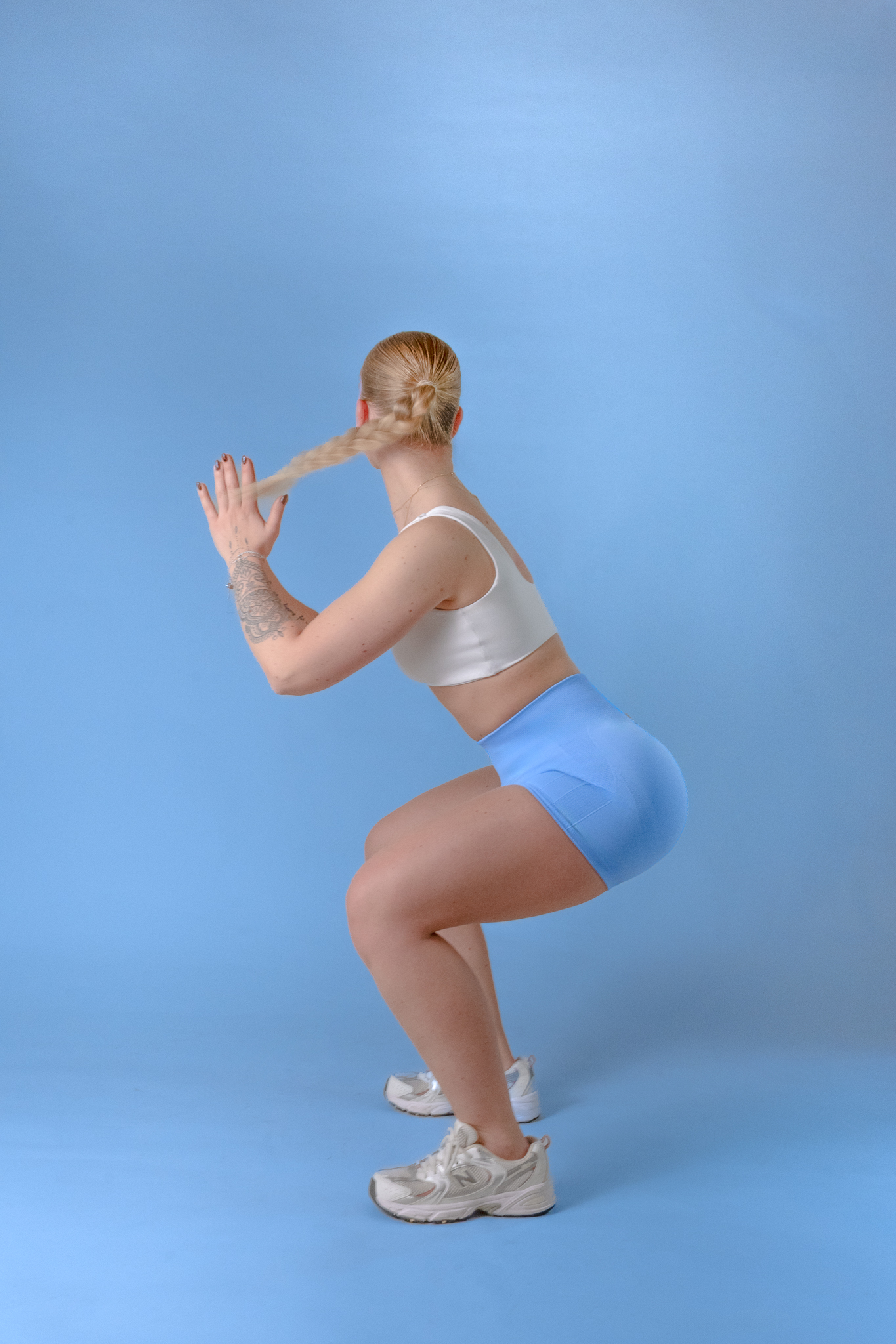 Rebelshape — tête en bas, legging bleu, tresses